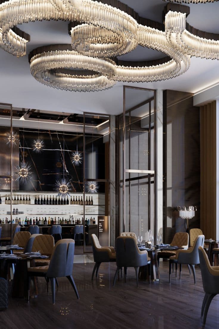 Upscale restaurant featuring swirling crystal chandeliers, plush velvet chairs, and a sleek marble bar.